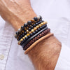 Men's gemstone bracelets with Agate, Tiger's Eye, Natural Fossil and Black Onyx, with 14k gold filled beads, next to 3 men's leather bracelets