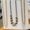 Set of necklaces displayed on a white stand with a blurred background