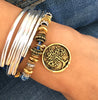 Stamped Tree of life pendant in gold shown on the Trixy in natural true blue leather